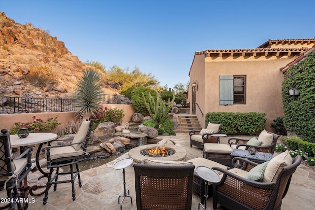 view of patio featuring stairway, an outdoor fire pit, and fence