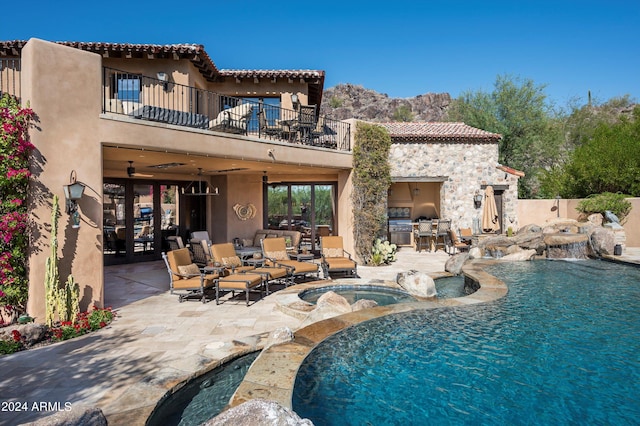 view of pool featuring an in ground hot tub, a patio, pool water feature, and a mountain view