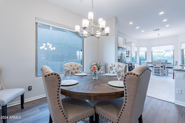 dining area with a chandelier and light hardwood / wood-style flooring