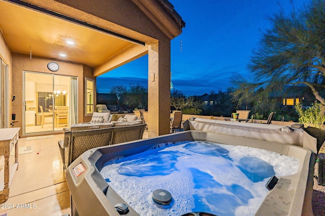 pool at dusk with a hot tub