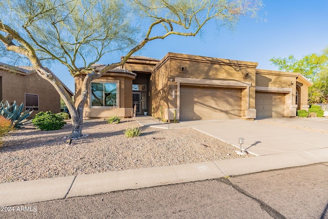 pueblo revival-style home featuring a garage