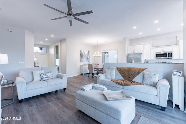 living room featuring dark hardwood / wood-style floors and ceiling fan with notable chandelier