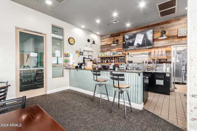 bar with tile patterned floors and wood walls