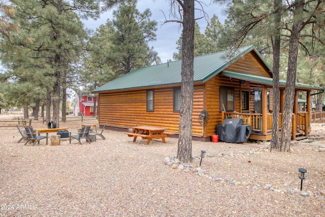 back of property featuring a porch and an outdoor fire pit