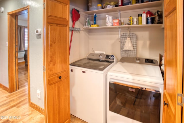 washroom featuring washer and clothes dryer and light wood-type flooring