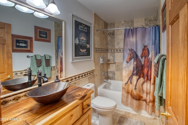 full bathroom featuring shower / bath combo, vanity, an inviting chandelier, toilet, and tile walls