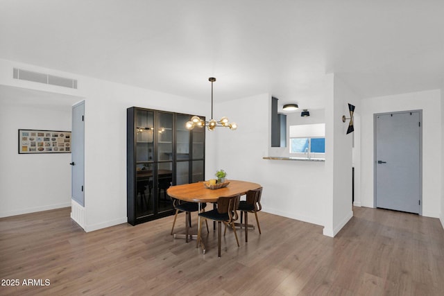 4600 N 68th St Unit 370, Scottsdale, AZ 85251 - dining area with wood finished floors, a chandelier, and baseboards