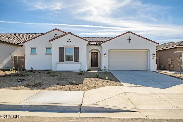 mediterranean / spanish home featuring a tile roof, an attached garage, driveway, and stucco siding