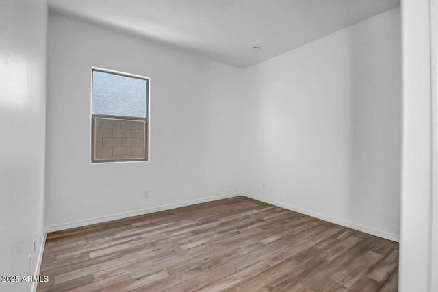 empty room with baseboards and light wood-style floors