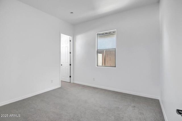 carpeted empty room with baseboards