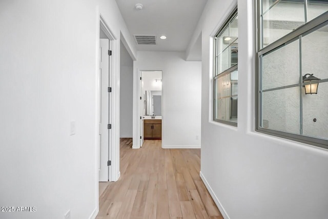 hallway featuring visible vents, recessed lighting, light wood-type flooring, and baseboards