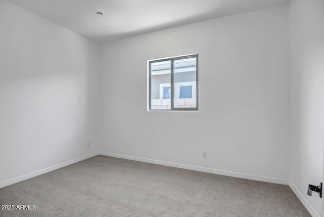 unfurnished room with baseboards and carpet flooring