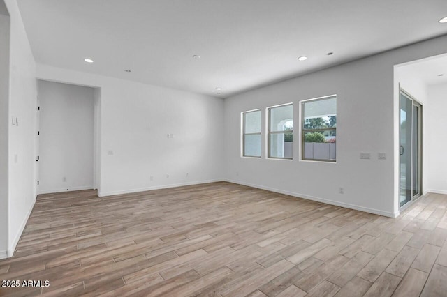 spare room featuring recessed lighting, baseboards, and light wood-style flooring