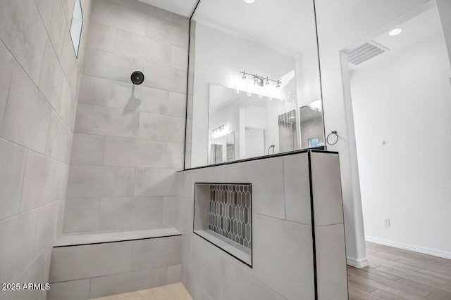 full bathroom featuring visible vents, baseboards, walk in shower, and wood finished floors