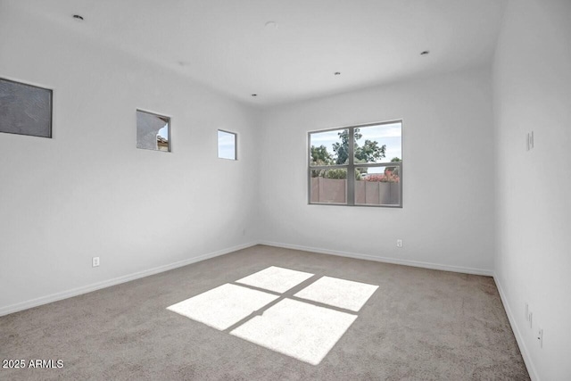 carpeted spare room featuring baseboards