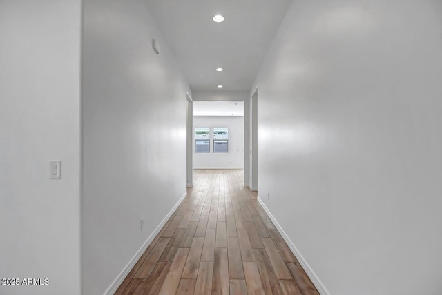 corridor featuring recessed lighting, wood finished floors, and baseboards