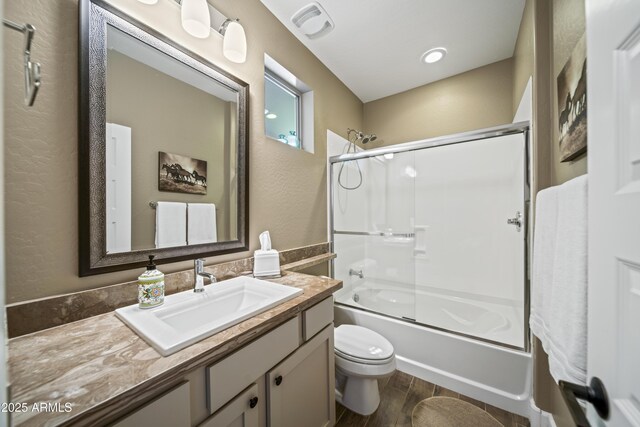 full bathroom with enclosed tub / shower combo, vanity, toilet, and hardwood / wood-style floors