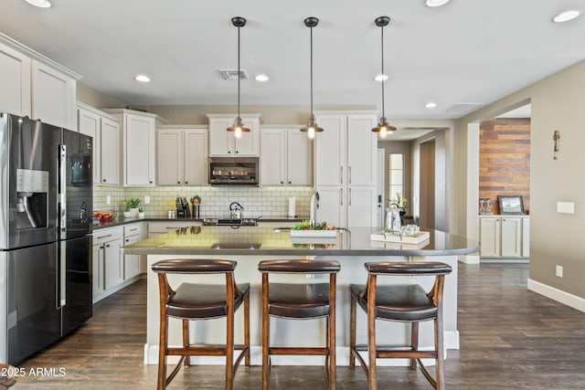 kitchen with white cabinets, hanging light fixtures, dark hardwood / wood-style floors, and fridge with ice dispenser