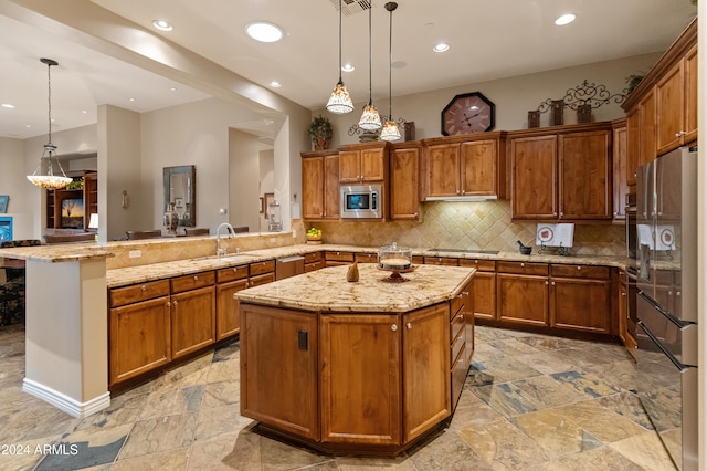 kitchen featuring stainless steel appliances, decorative light fixtures, and a kitchen island