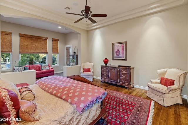 bedroom featuring ceiling fan, ornamental molding, and wood-type flooring