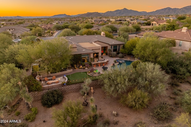 aerial view at dusk featuring a mountain view