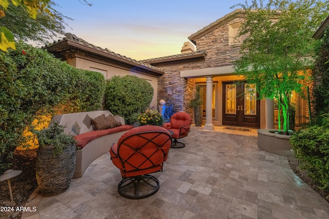 patio terrace at dusk featuring french doors