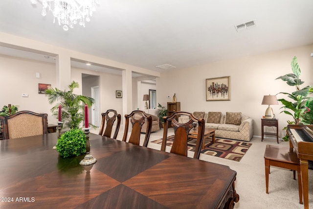 dining room with carpet floors and a chandelier