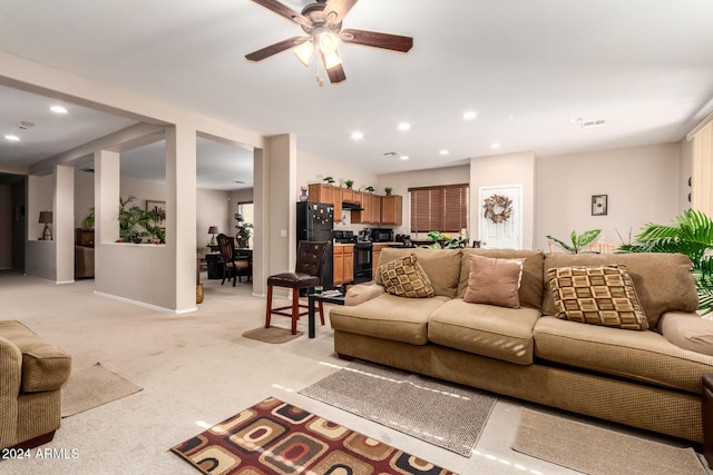 carpeted living room with ceiling fan