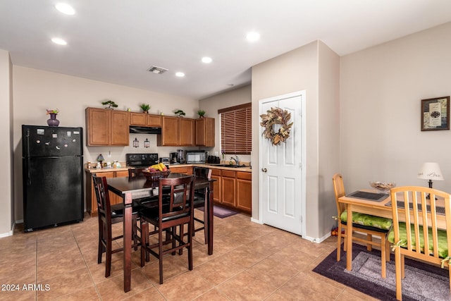 kitchen with light tile patterned flooring, sink, and black appliances