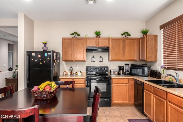 kitchen with sink, light tile patterned floors, and black appliances