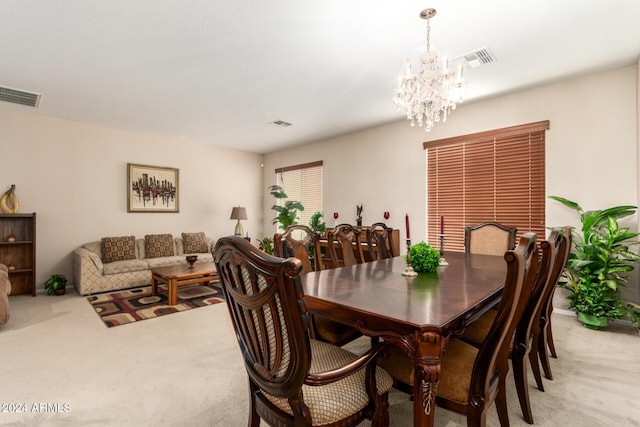 carpeted dining area featuring a chandelier