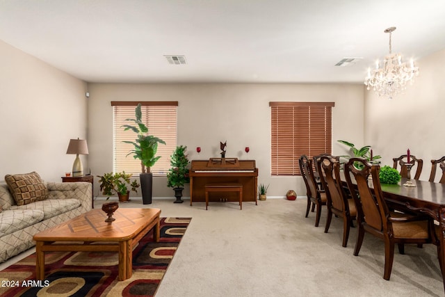 living room featuring light carpet and a chandelier