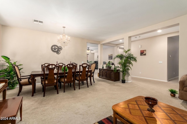 dining space with light colored carpet and ceiling fan with notable chandelier