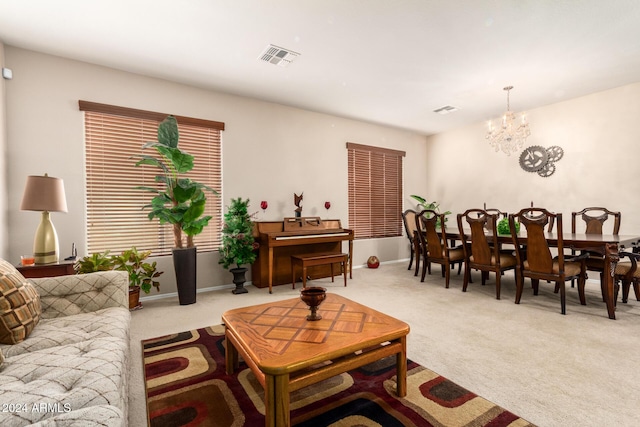 living room with light colored carpet and a notable chandelier