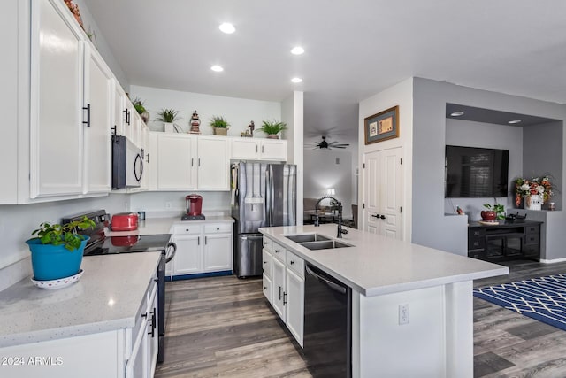 kitchen featuring appliances with stainless steel finishes, dark hardwood / wood-style flooring, sink, white cabinets, and an island with sink