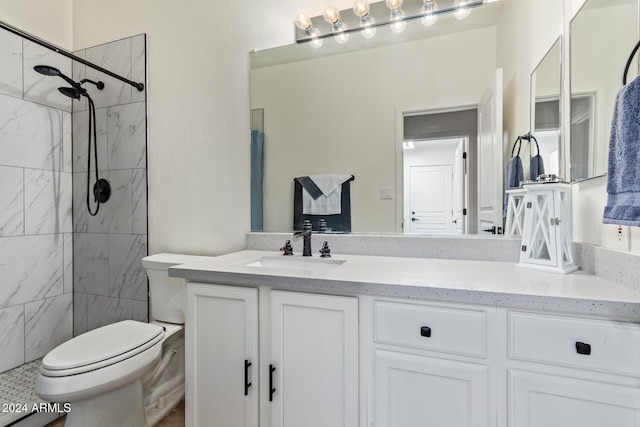 bathroom featuring vanity, toilet, and tiled shower