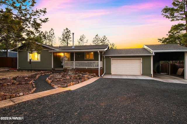 ranch-style home with a porch, an attached garage, fence, an attached carport, and driveway