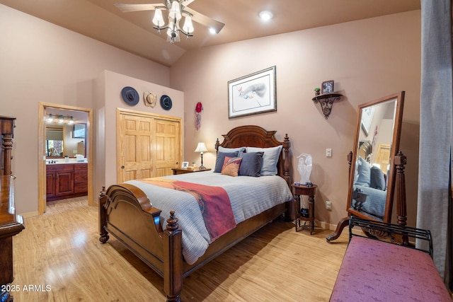 bedroom with connected bathroom, vaulted ceiling, light hardwood / wood-style flooring, a closet, and ceiling fan