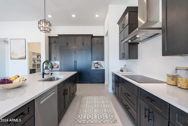 kitchen featuring wall chimney range hood, sink, stainless steel dishwasher, black electric cooktop, and decorative light fixtures