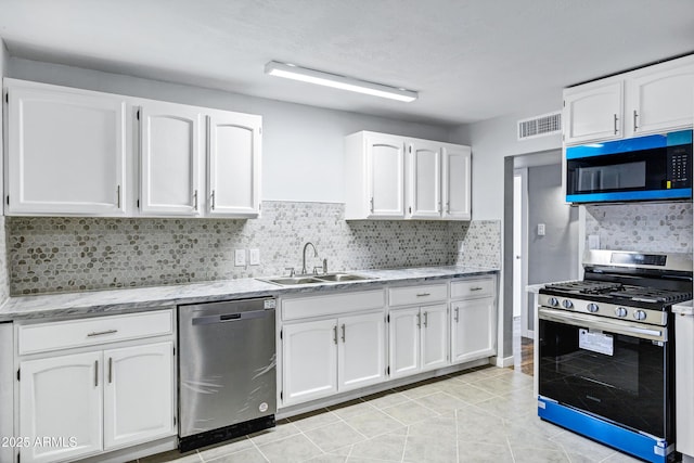 kitchen with backsplash, visible vents, appliances with stainless steel finishes, a sink, and white cabinets