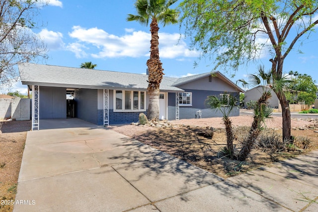 single story home featuring concrete driveway and a carport