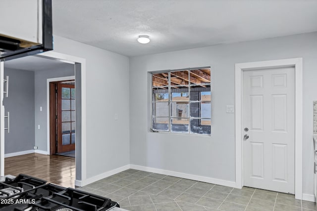 interior space with a textured ceiling and baseboards