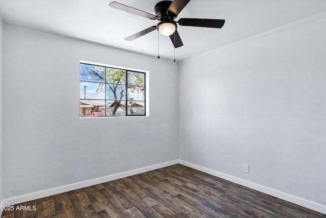 spare room with baseboards, a ceiling fan, and dark wood finished floors