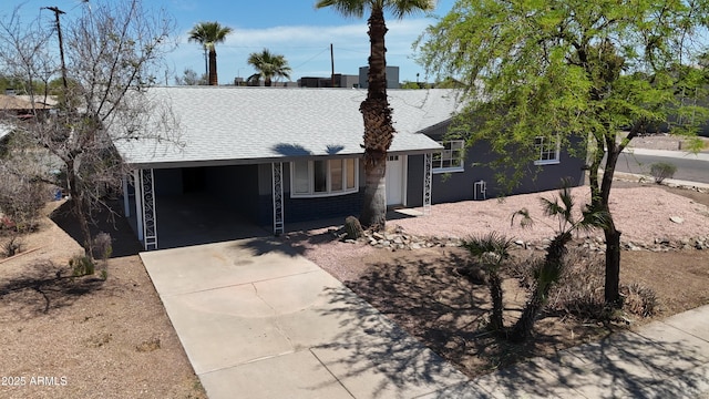single story home with a shingled roof and concrete driveway