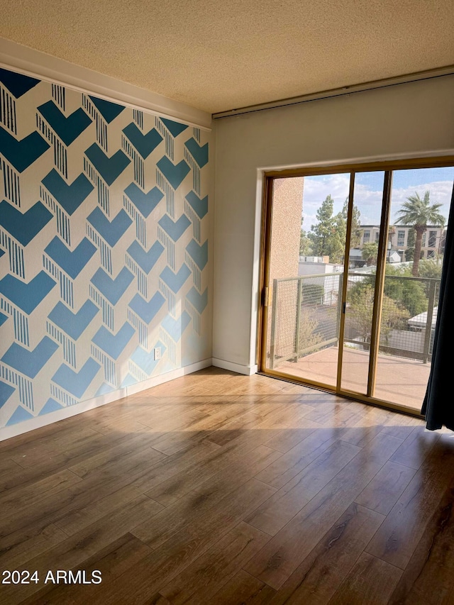 unfurnished room featuring hardwood / wood-style floors and a textured ceiling