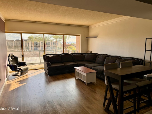 living room with a textured ceiling, ornamental molding, and hardwood / wood-style flooring