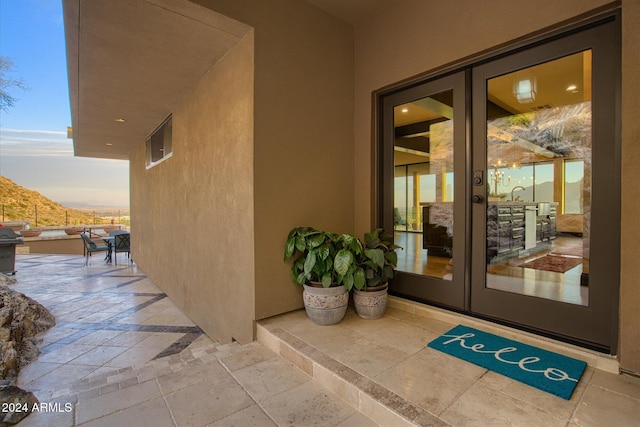 exterior entry at dusk featuring a mountain view and french doors