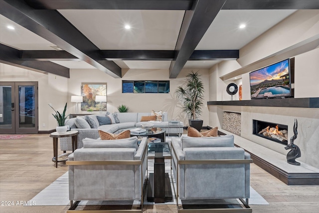 living room with beam ceiling, a fireplace, and light hardwood / wood-style floors