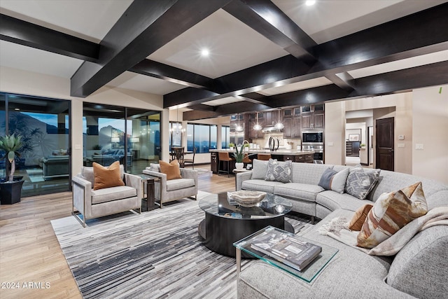 living room with beam ceiling, sink, and light hardwood / wood-style floors