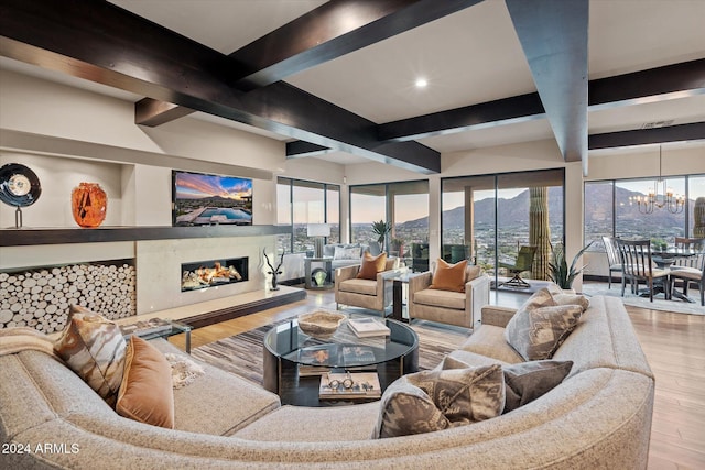 living room featuring beamed ceiling, a notable chandelier, and light hardwood / wood-style flooring